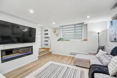 a living room with a couch and a flat screen tv at Stylish 2BR Townhome - Near YYC Airport - Free Parking in Calgary