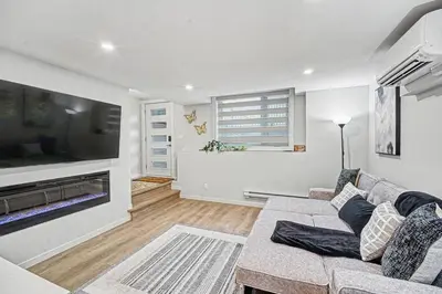 a living room with a couch and a flat screen tv at Stylish 2BR Townhome - Near YYC Airport - Free Parking in Calgary