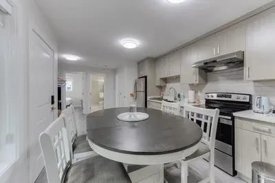 a kitchen with a table and chairs in a room at The Cozy Garden Suite - South Surrey Stay in White Rock