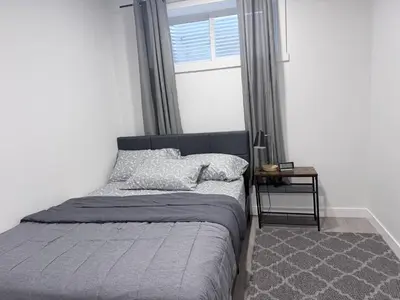 a bed sitting in a bedroom with a window at Charming Family-Friendly House Rental in Edmonton in Edmonton