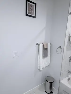 a white bathroom with towels hanging on the wall at Charming Family-Friendly House Rental in Edmonton in Edmonton