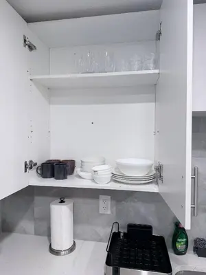 a kitchen with white cabinets with plates and dishes at Charming Family-Friendly House Rental in Edmonton in Edmonton