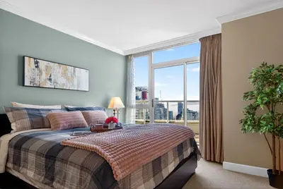 a bedroom with a bed and a large window at Stunning 2BR Apartment with Best Mountain View Downtown in Vancouver