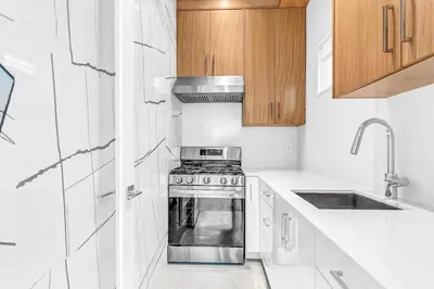 a white kitchen with a stove and a sink at Fabulous Modern Home Near Downtown Vancouver in Vancouver