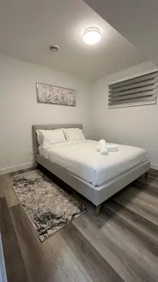 a bedroom with a bed in a room with a rug at Cozy 2 bedroom suite in Edmonton
