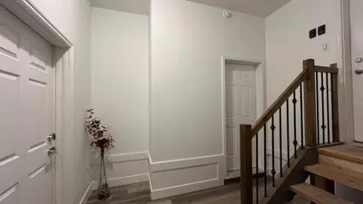 a hallway with a staircase with a white wall at Cozy 2 bedroom suite in Edmonton
