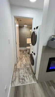 a bathroom with a washing machine and a toilet at Cozy 2 bedroom suite in Edmonton