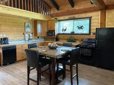 a kitchen with a table and chairs in a cabin at The Yellowstone cabin - part of Bear Creek Cabins in Winfield