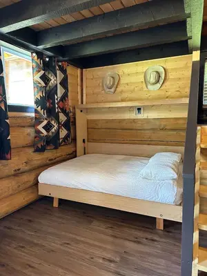 a bedroom with a bed in a log cabin at The Yellowstone cabin - part of Bear Creek Cabins in Winfield