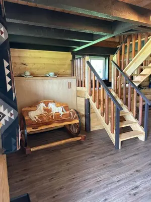 a room with a bed in a cabin with stairs at The Yellowstone cabin - part of Bear Creek Cabins in Winfield