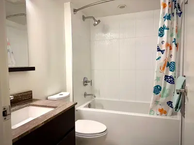a bathroom with a toilet and a tub and a sink at Pleasant and convenient 1B1B close to Richmond Center in Richmond