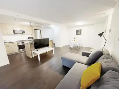 a living room with a couch and a kitchen at Bright & Cozy 2B2B near transit in Richmond in Richmond