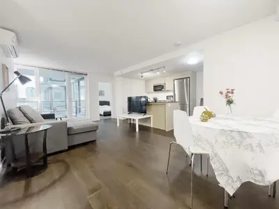 a white living room with a table and a couch at Bright & Cozy 2B2B near transit in Richmond in Richmond