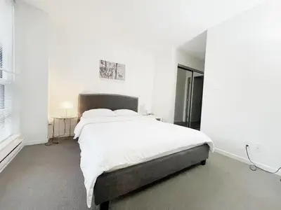 a white bedroom with a large bed with white sheets at Bright & Cozy 2B2B near transit in Richmond in Richmond