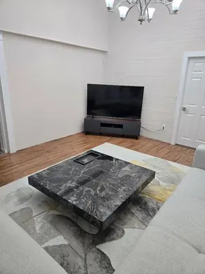 a living room with a table in front of a tv at 3 BR Lux home with AC in a central location in Delta