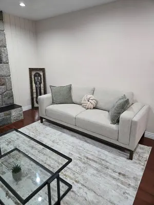 a living room with a couch and a table at 3 BR Lux home with AC in a central location in Delta