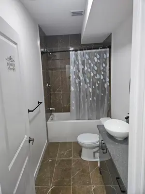 a bathroom with a toilet and a sink and a tub at Your home away from home comfortable, and calm, in Edmonton
