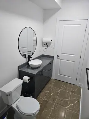 a bathroom with a toilet and a sink and a mirror at Your home away from home comfortable, and calm, in Edmonton