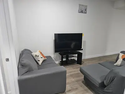 a living room with a couch and a tv at Your home away from home comfortable, and calm, in Edmonton