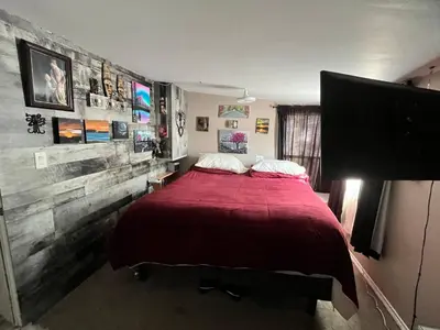a bedroom with a large bed with a red blanket at Rustic suite in small town Alberta Canada in Penhold