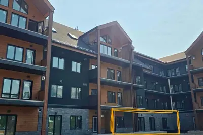 an apartment building with a yellow ribbon around it at New Condo with Pool and Hot Tub Sleeps 9 in Canmore