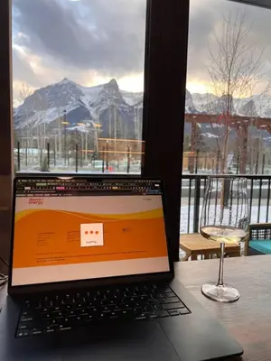 a laptop computer sitting on a table in front of a window at New Condo with Pool and Hot Tub Sleeps 9 in Canmore