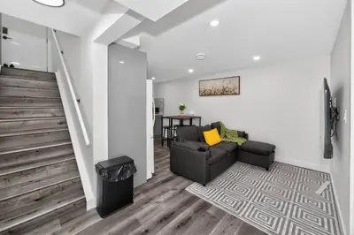 a living room with a couch and a staircase at New 2BR Home - Family Friendly - Near YYC Airport & Downtown - 4412 - DN in Calgary