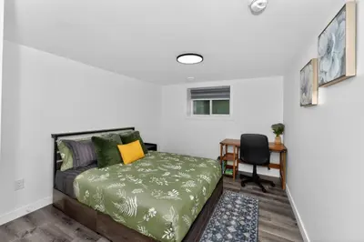 a bedroom with a bed and a desk with a chair at New 2BR Home - Family Friendly - Near YYC Airport & Downtown - 4412 - DN in Calgary