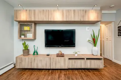 a living room with a large tv on a wall at Spacious One Bedroom Queen Bed Inner City Stay in Calgary