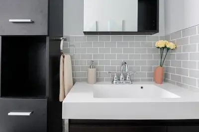 a white sink in a kitchen with a vase of flowers at Spacious One Bedroom Queen Bed Inner City Stay in Calgary