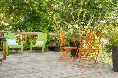 a group of chairs and tables on a deck at Spacious One Bedroom Queen Bed Inner City Stay in Calgary