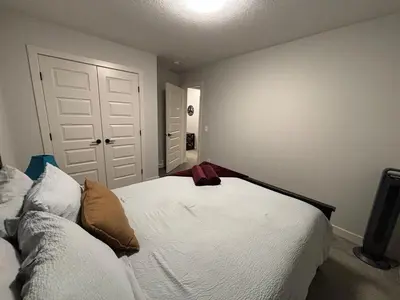 a bedroom with a white bed and a white door at Luxury 3bedroom House with Kingsize Master bedroom in Airdrie