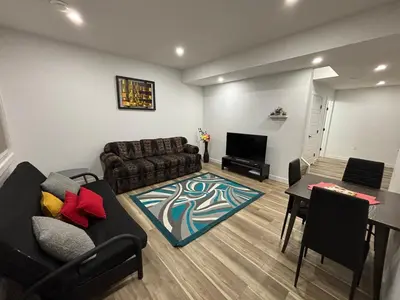 a living room with a couch and a table at Fowler Road Cozy Lower Suite in Airdrie