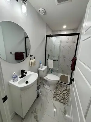 a bathroom with a sink and a toilet and a mirror at Fowler Road Cozy Lower Suite in Airdrie
