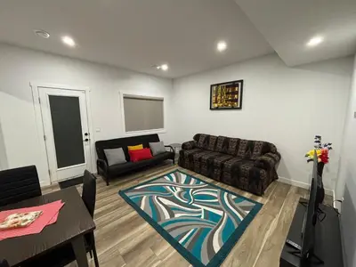 a living room with a couch and a table at Fowler Road Cozy Lower Suite in Airdrie