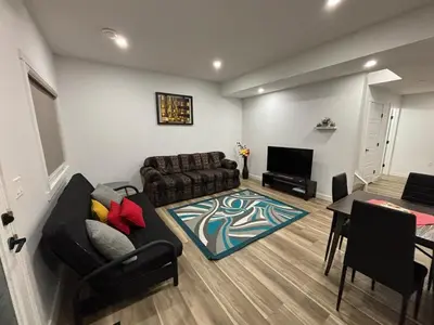 a living room with a couch and a table at Fowler Road Cozy Lower Suite in Airdrie