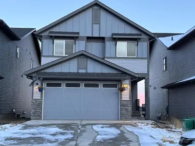 a house with a garage door in front of it at Luxury 4 Bedroom Entire House with Basement in Airdrie