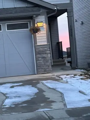 a house with a garage with snow on the driveway at Luxury 4 Bedroom Entire House with Basement in Airdrie