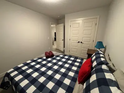 a bedroom with a blue and white checkered bed at Luxury 4 Bedroom Entire House with Basement in Airdrie