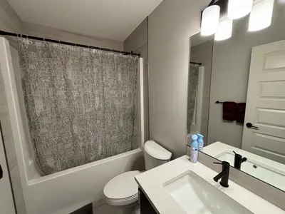 a bathroom with a sink and a toilet and a shower at Luxury 4 Bedroom Entire House with Basement in Airdrie