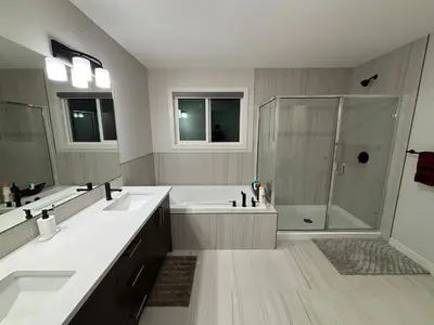 a large bathroom with two sinks and a shower at Luxury 4 Bedroom Entire House with Basement in Airdrie