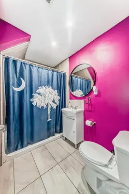 a pink and purple bathroom with a toilet and a mirror at Cozy Vacation Home in Calgary