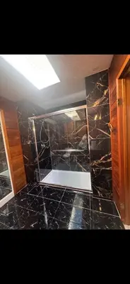 a bathroom with a black tiled floor and a ceiling at Picturesque and Comfy Escape with Waterfall View in Garden Bay