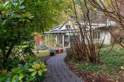 a walkway leading to a house in a garden at Picturesque and Comfy Escape with Waterfall View in Garden Bay