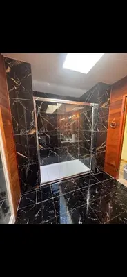 a bathroom with a shower with black marble at Picturesque and Comfy Escape with Waterfall View in Garden Bay