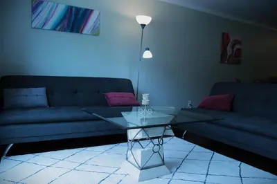 a living room with a couch and a glass table at Creekside Haven on a Sleddog Farm in Dovercourt