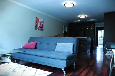 a living room with a blue couch and a table at Creekside Haven on a Sleddog Farm in Dovercourt