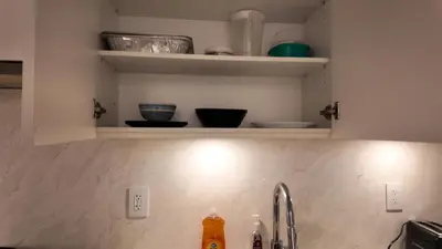 a kitchen counter with a sink and some shelves at Cozy 1 bed and 1bath suit in Surrey