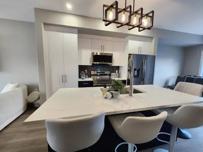 a kitchen with a large white table and chairs at Harmony Haven in Drumheller in Drumheller