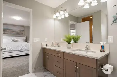 a bathroom with a sink and a large mirror at A beautiful home in Airdrie in Airdrie